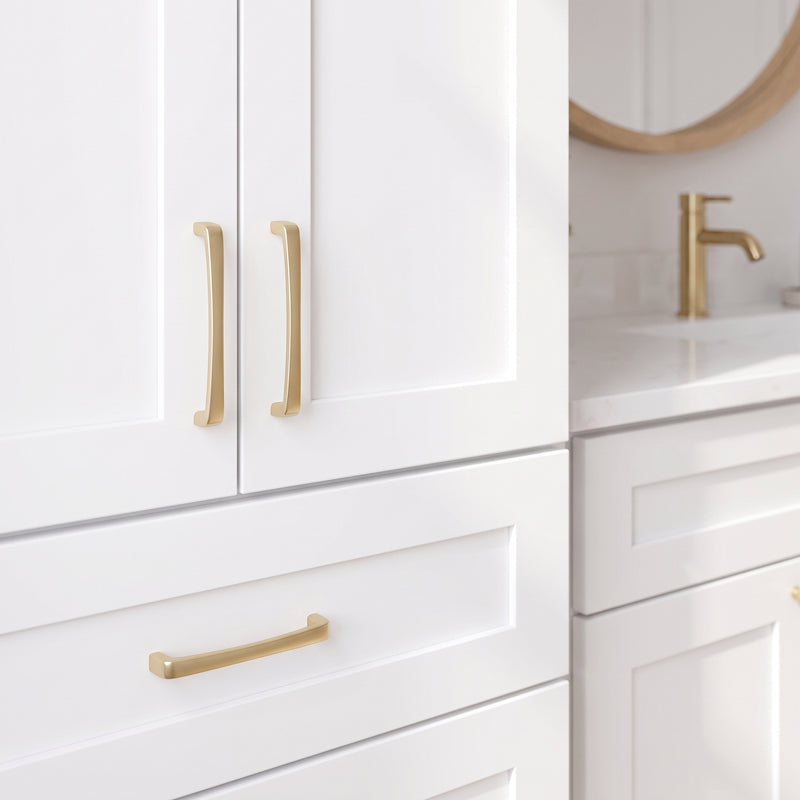 Close-up of white shaker doors and satin gold bar pulls